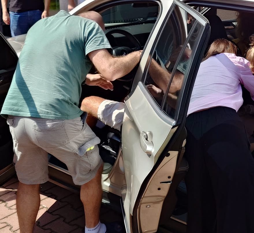 Uczestnicy szkolenia ćwiczą pomoc poszkodowanemu w samochodzie